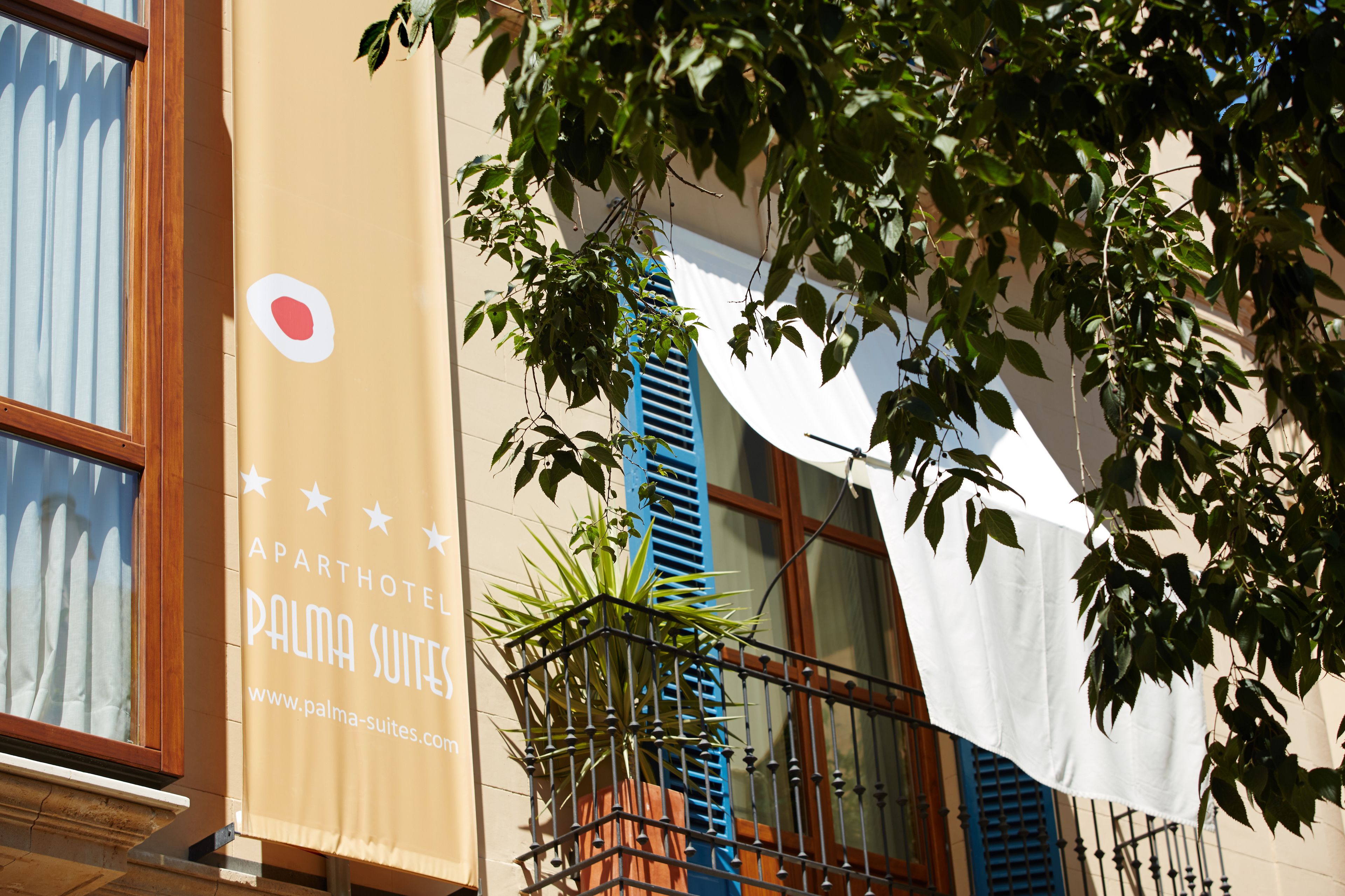 A building with a sign for 'APARTHOTEL PALMA SUITES' and a website address.