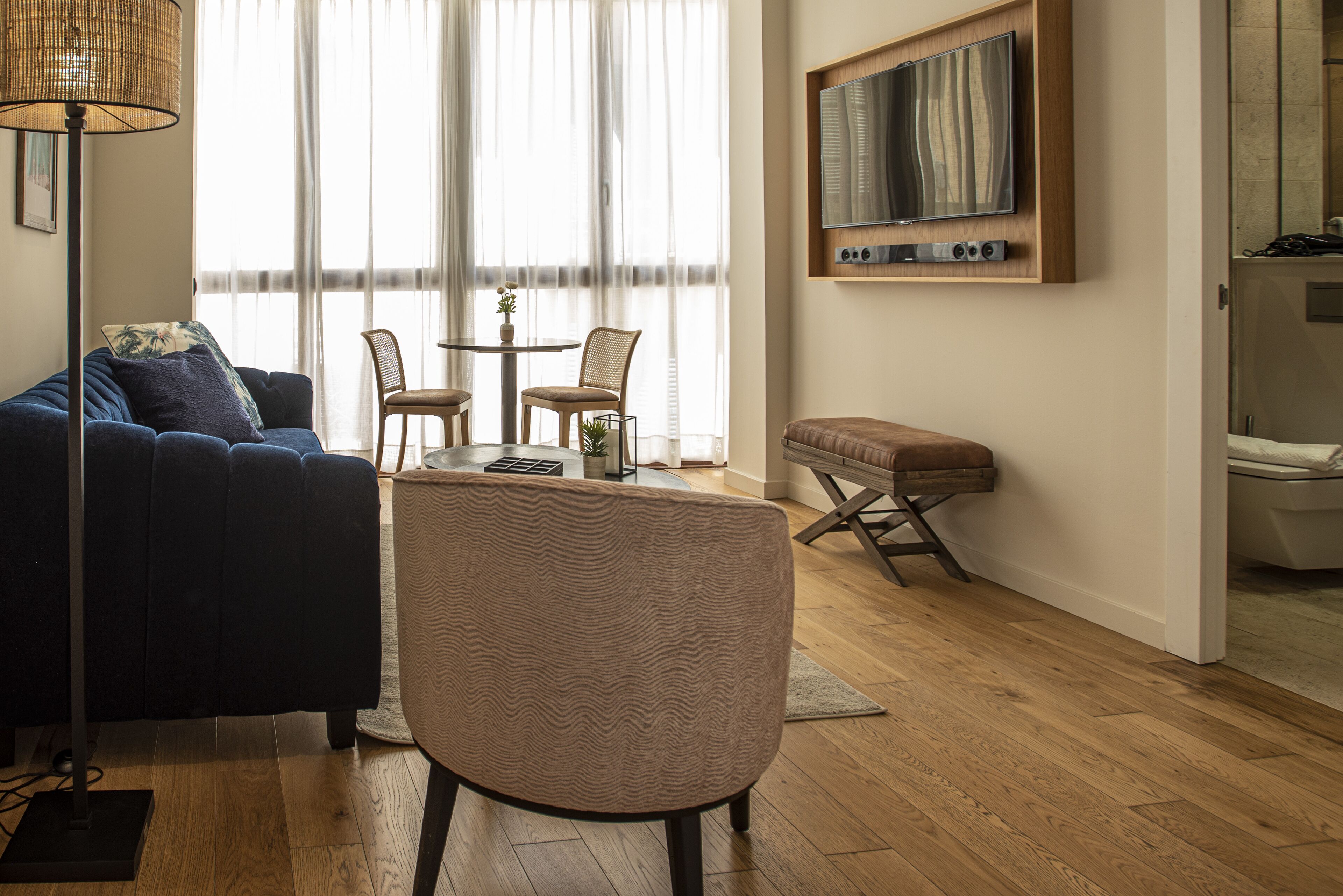 Una sala de estar moderna con un sofá, una mesa de centro y un televisor montado en la pared.