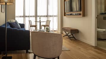 Una sala de estar moderna con un sofá, una mesa de centro y un televisor montado en la pared.