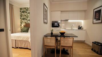 A compact living space with a bed, kitchenette, and dining area.