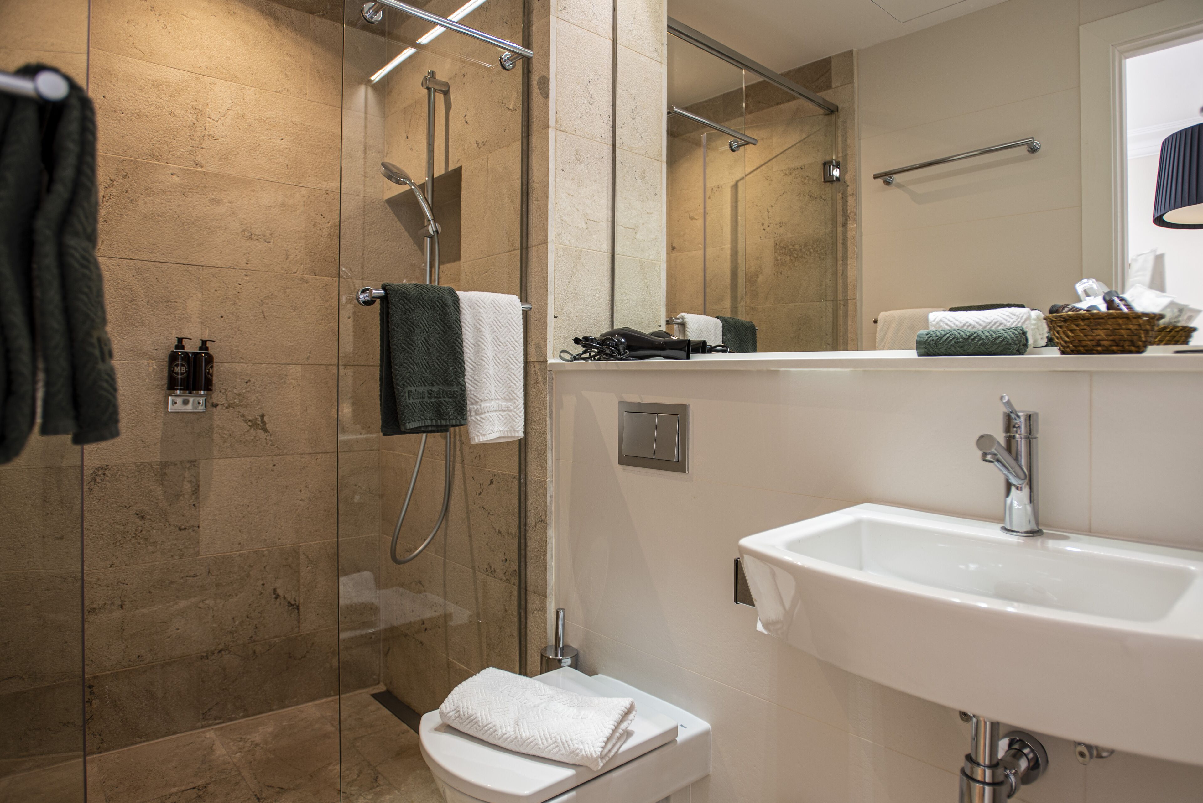 A modern bathroom with a glass-enclosed shower, a white sink, and a mirror above the sink.