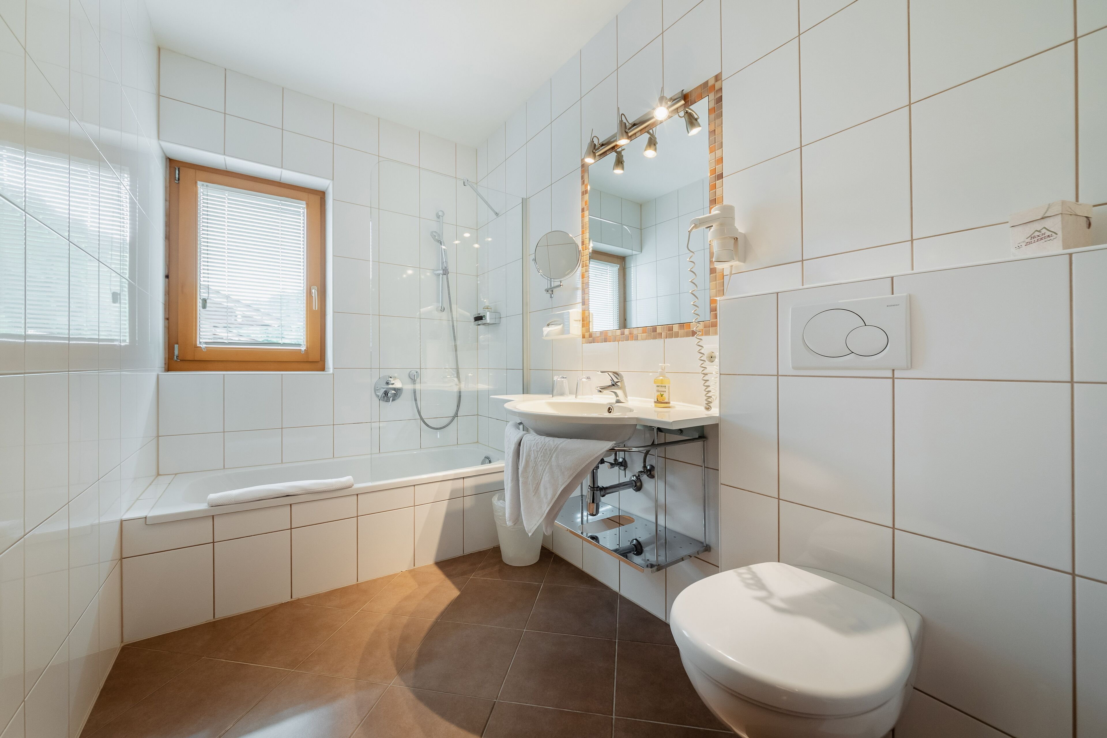 A modern bathroom with a bathtub, a toilet, and a sink.