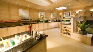 Una cocina amplia con armarios de madera, encimera de granito y diversos electrodomésticos.