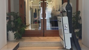 A staircase leading to a double door entrance with a ramp on the right side. - Hotel Agli Artisti (Venice)