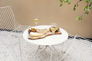 A round table with a white tablecloth, two white chairs, a plate with cheese and crackers, and two glasses of white wine. - No.5 Maddox Street (London)