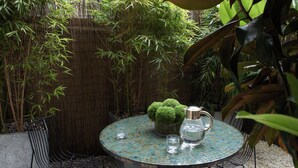 A round table with a mosaic top, two chairs, a small potted plant, and a metal pitcher. - No.5 Maddox Street (London)