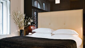 A modern bedroom with a large bed, a vase with flowers, and a window. - No.5 Maddox Street (London)