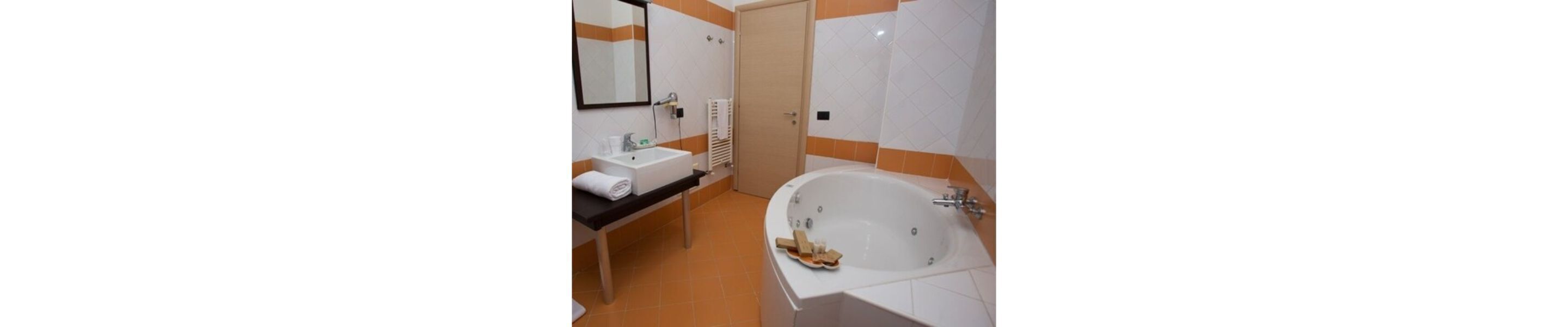 Ein Badezimmer mit Waschbecken, Spiegel und Badewanne.