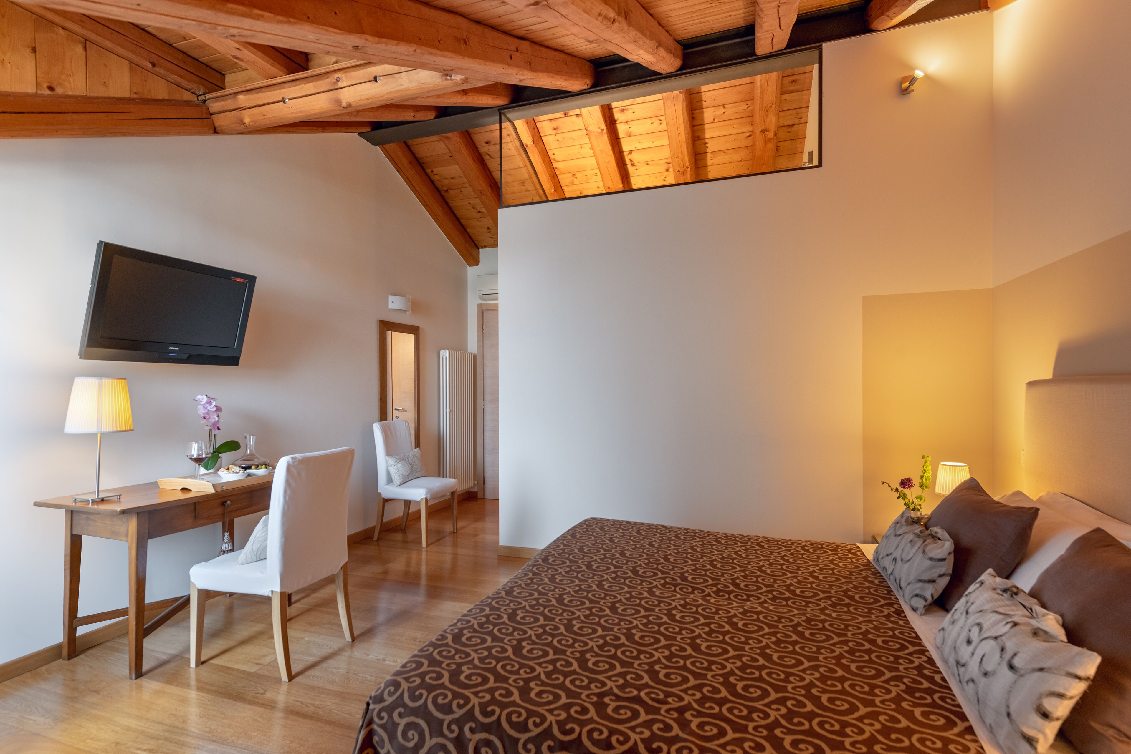 Une chambre à coucher avec un lit, un bureau, une chaise et un téléviseur.