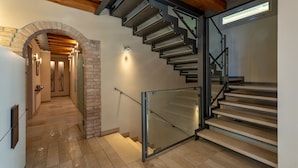Una escalera moderna con barandillas de vidrio y techo de madera.