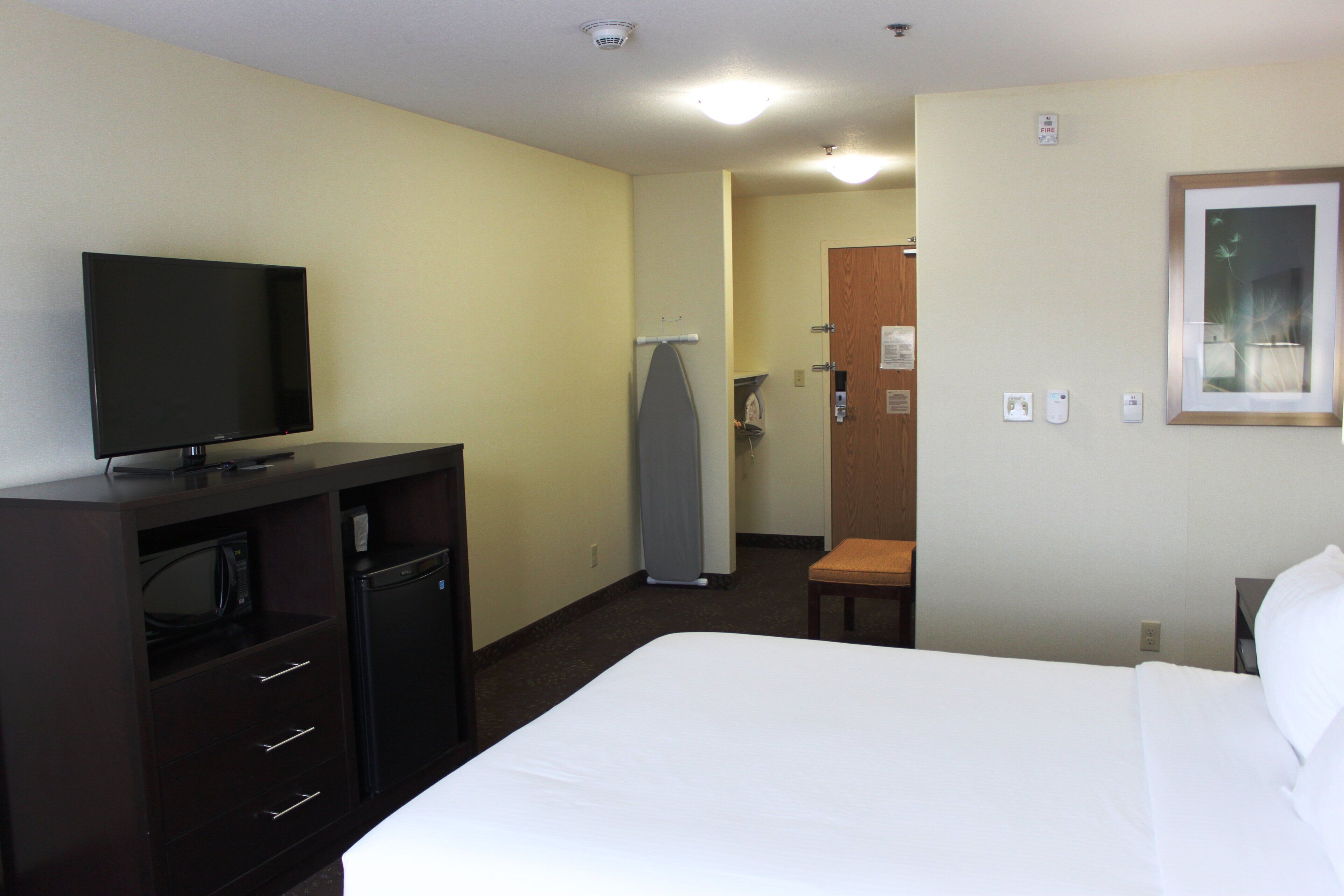 Una habitación de hotel con cama, televisión, escritorio y una silla.