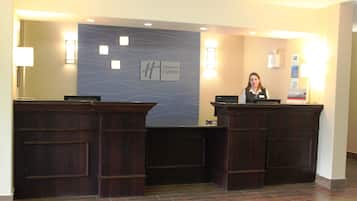 A reception desk with a Holiday Inn Express sign, a nameplate, and a computer.