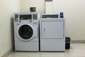 Un appareil combiné lave-linge et sèche-linge à chargement frontal, doté d’un écran numérique, d’un panneau de commande et d’une étiquette d’information.