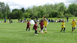 Een grasveld met mensen, sommigen in sportkleding, wat duidt op een activiteit of evenement buiten.