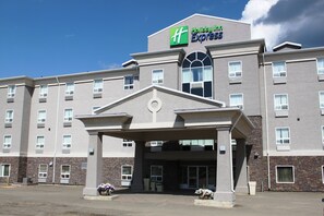Een Holiday Inn Express hotel met een centrale ingang, meerdere ramen en een gevel van baksteen.