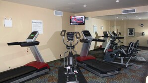 A fitness center with treadmills, elliptical machines, and a digital display. - Holiday Inn Express Yorkton East by IHG (Yorkton)