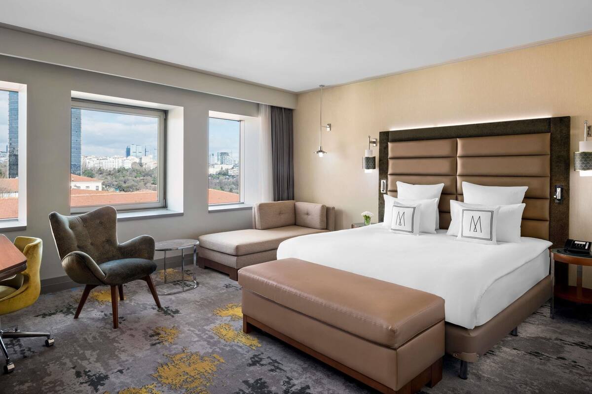 Een hotelkamer met een groot bed, een bank, een stoel en een bureau.