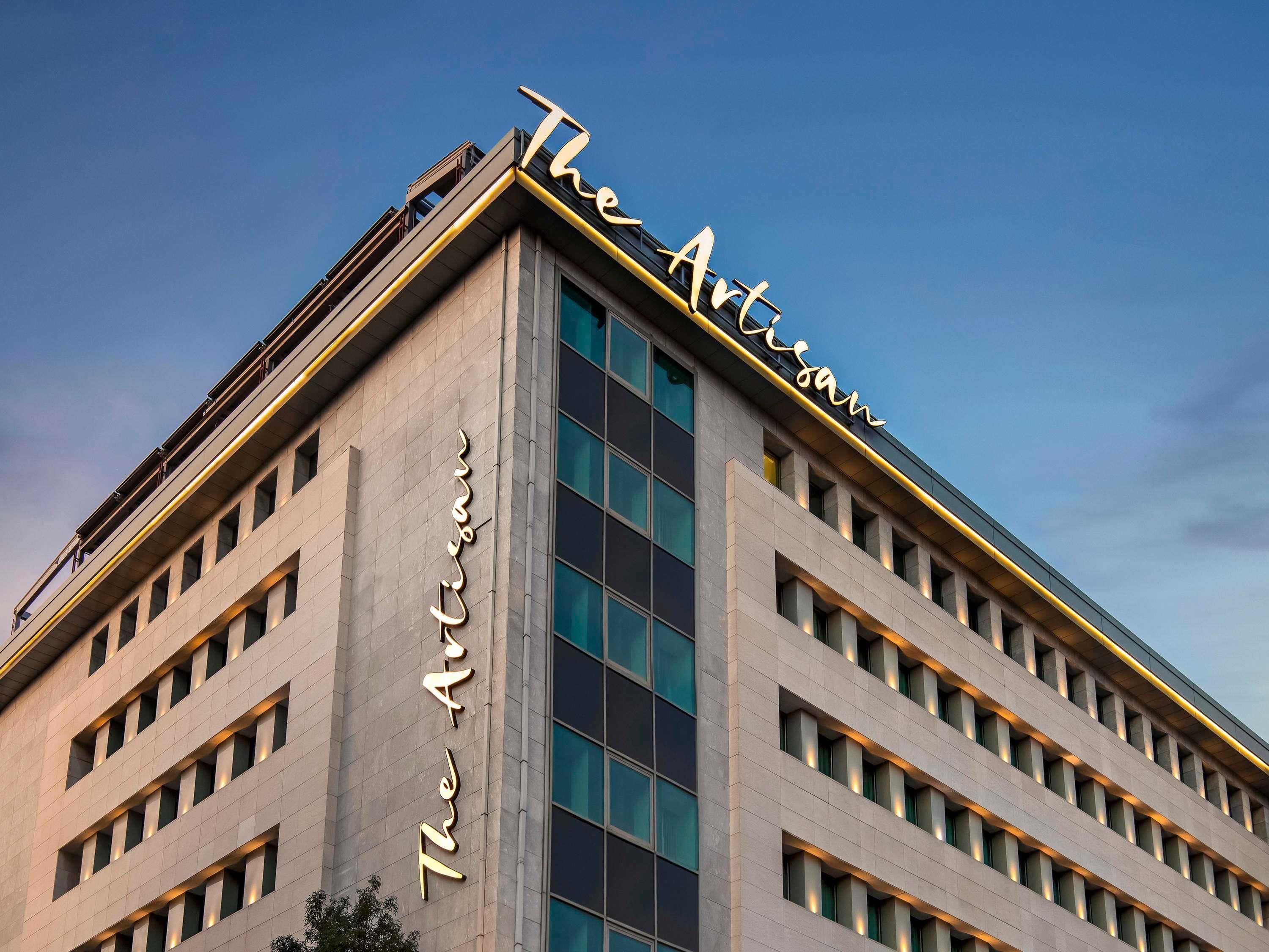 Un edificio con un letrero llamativo que dice 'The Artisan Hotel'.