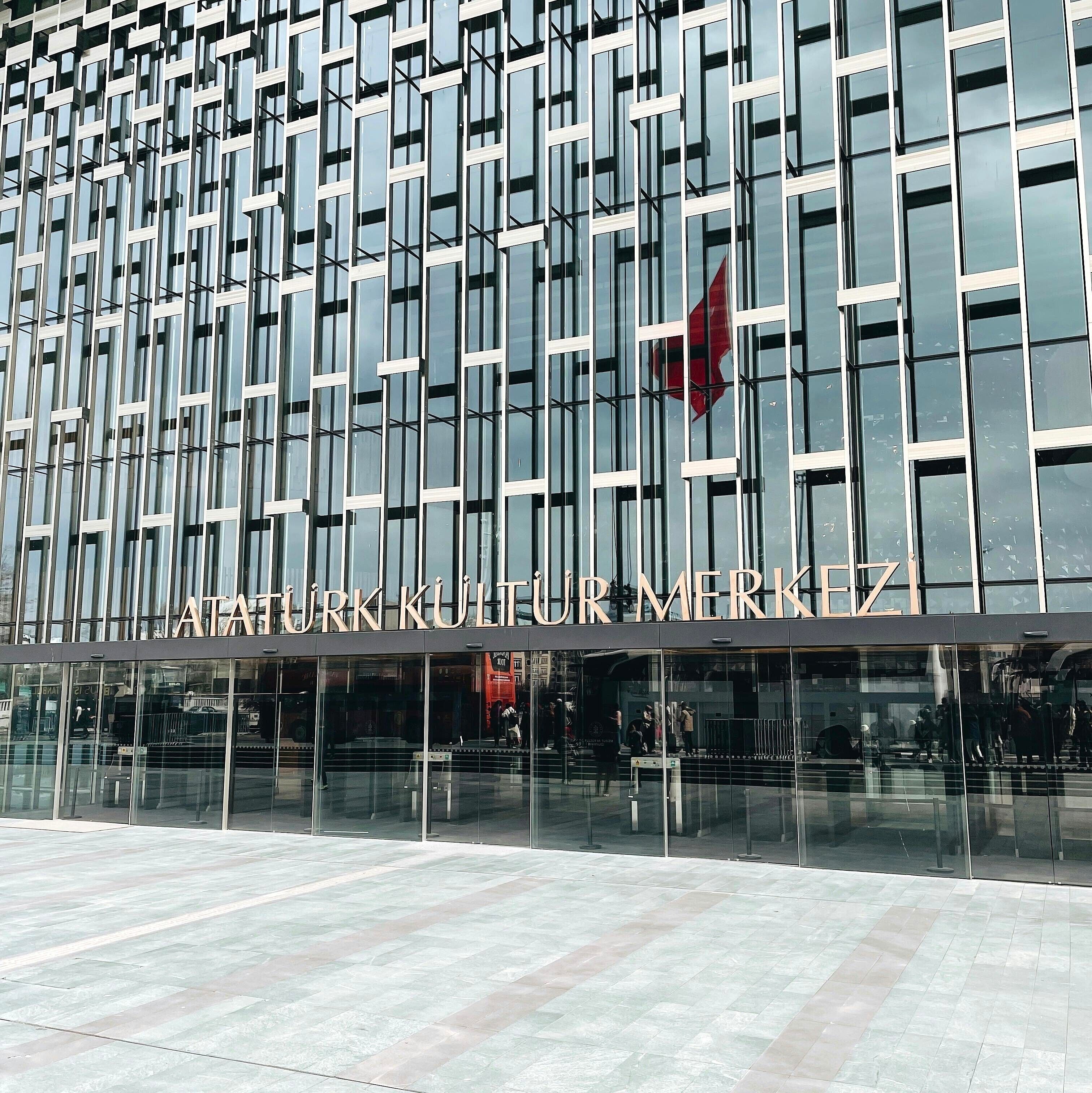 A modern building facade with a grid of windows and a sign reading 'ATATURK KULTUR MERKEZI'.