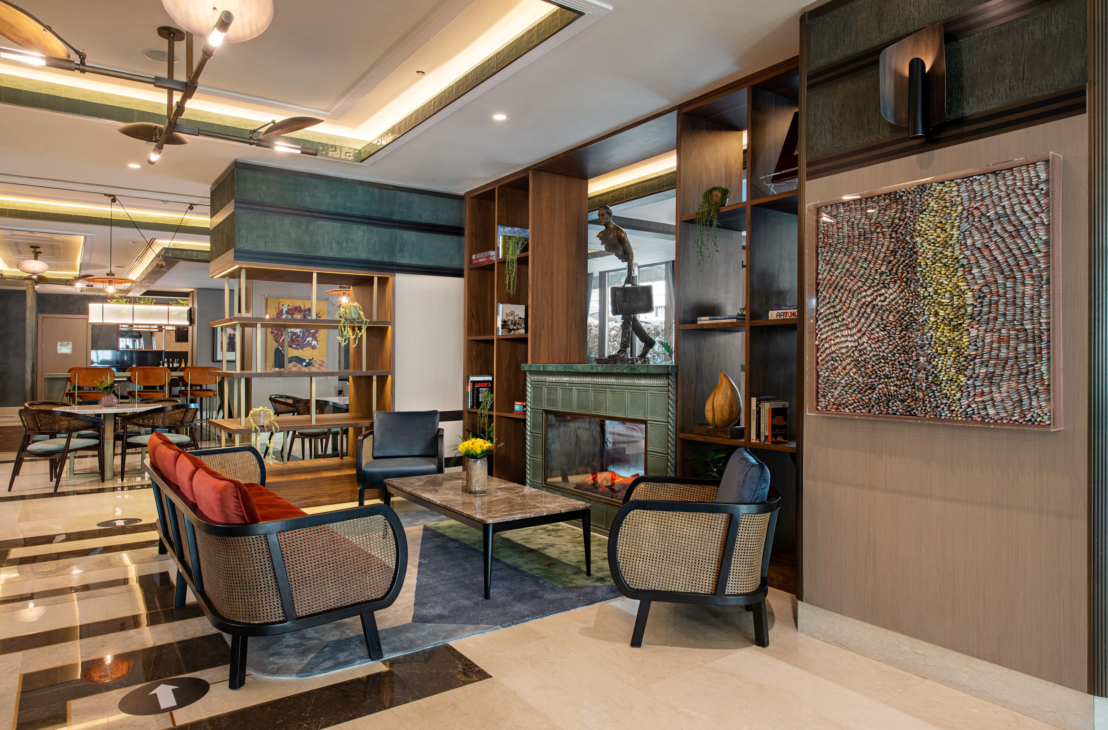 A modern lobby with a fireplace, seating area, and a large abstract art piece.
