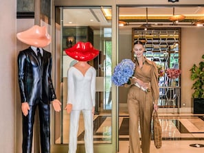 Mannequins in formal attire, a reception area with a glass door, and a plant. - The Artisan Hotel Istanbul - MGallery Collection (Istanbul)