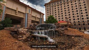 L’entrée d’un hôtel agrémentée d’une cascade, avec un grand bâtiment en arrière-plan.