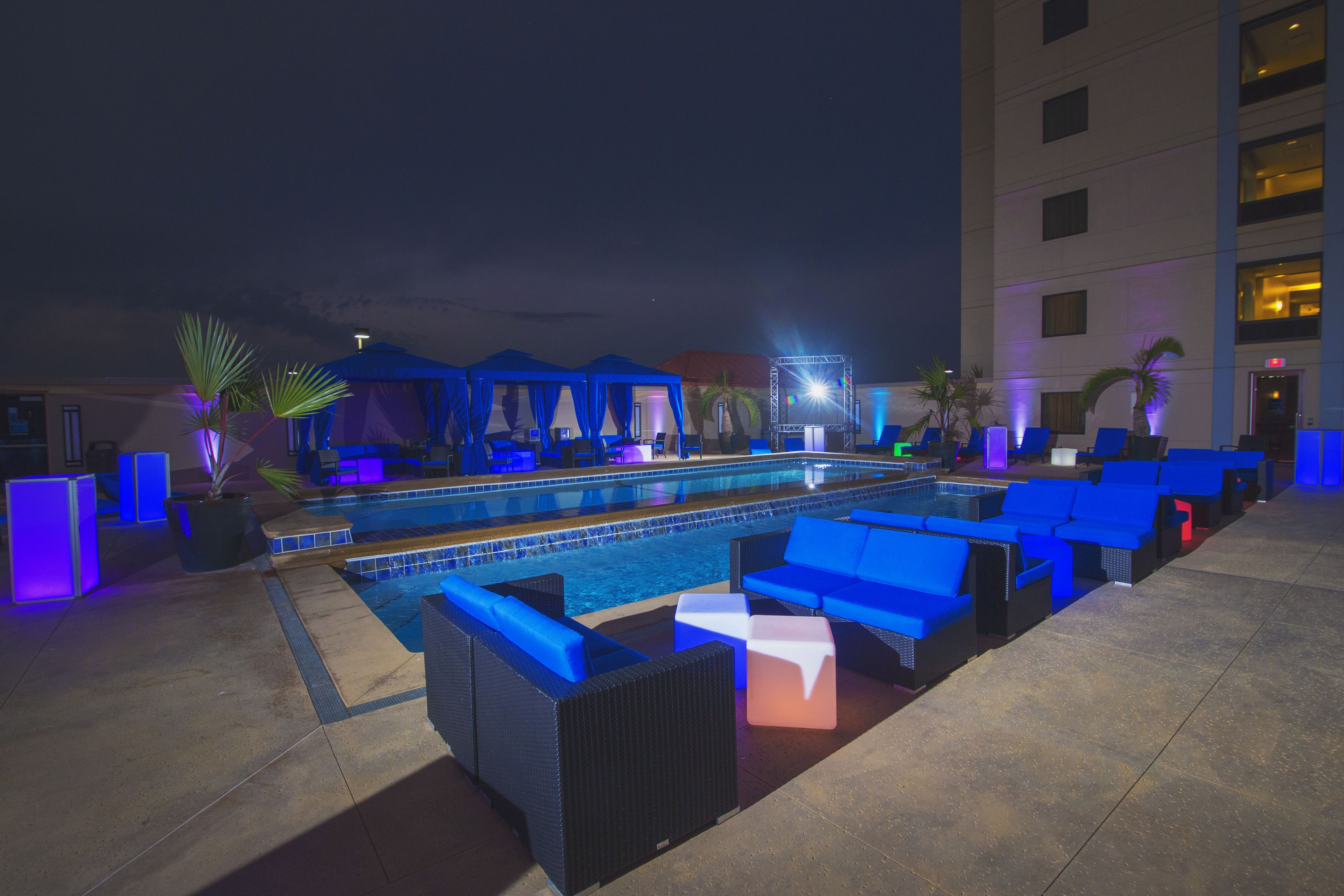 A pool area with blue lounge chairs and a pool.
