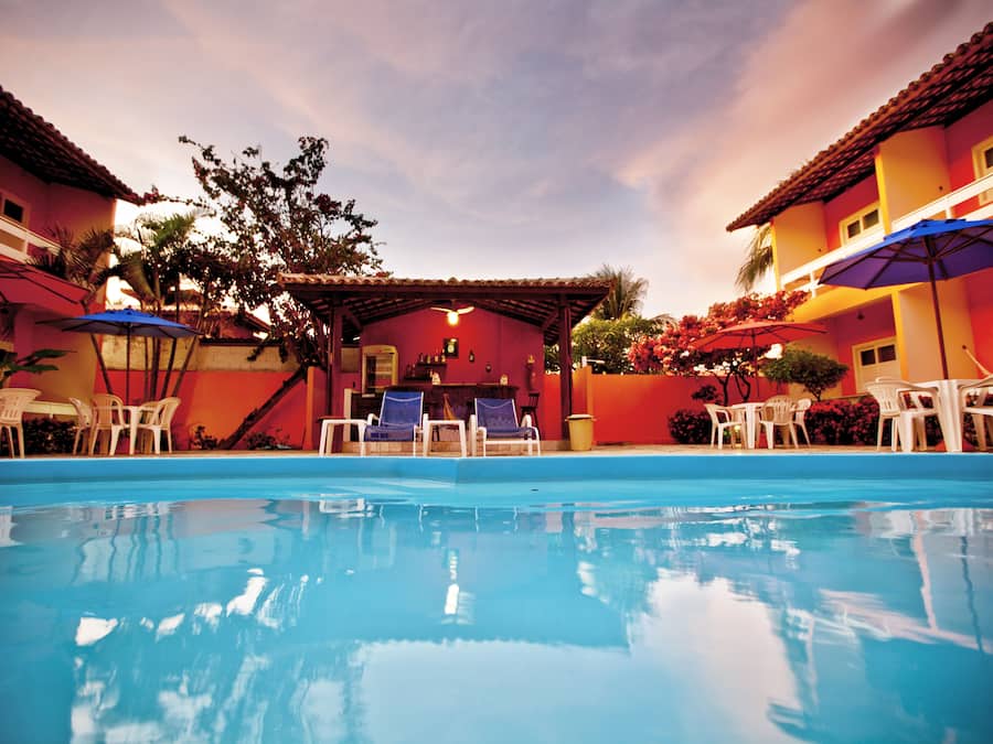 Una piscina al aire libre, sombrillas, sillones reclinables de piscina