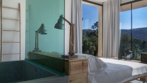 A modern bedroom with a glass ceiling, a bed, a wooden dresser, and a desk with a lamp. - Cooking and Nature Emotional Hotel (Porto de Mos)