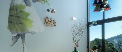 A modern room with a large window, a wooden desk, and a wall mural.