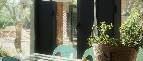 Une table avec des chaises, une plante en pot et un panier sur lequel est écrit le mot « SE ».