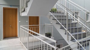 Un intérieur moderne avec un escalier, des portes en bois et une plante en pot.