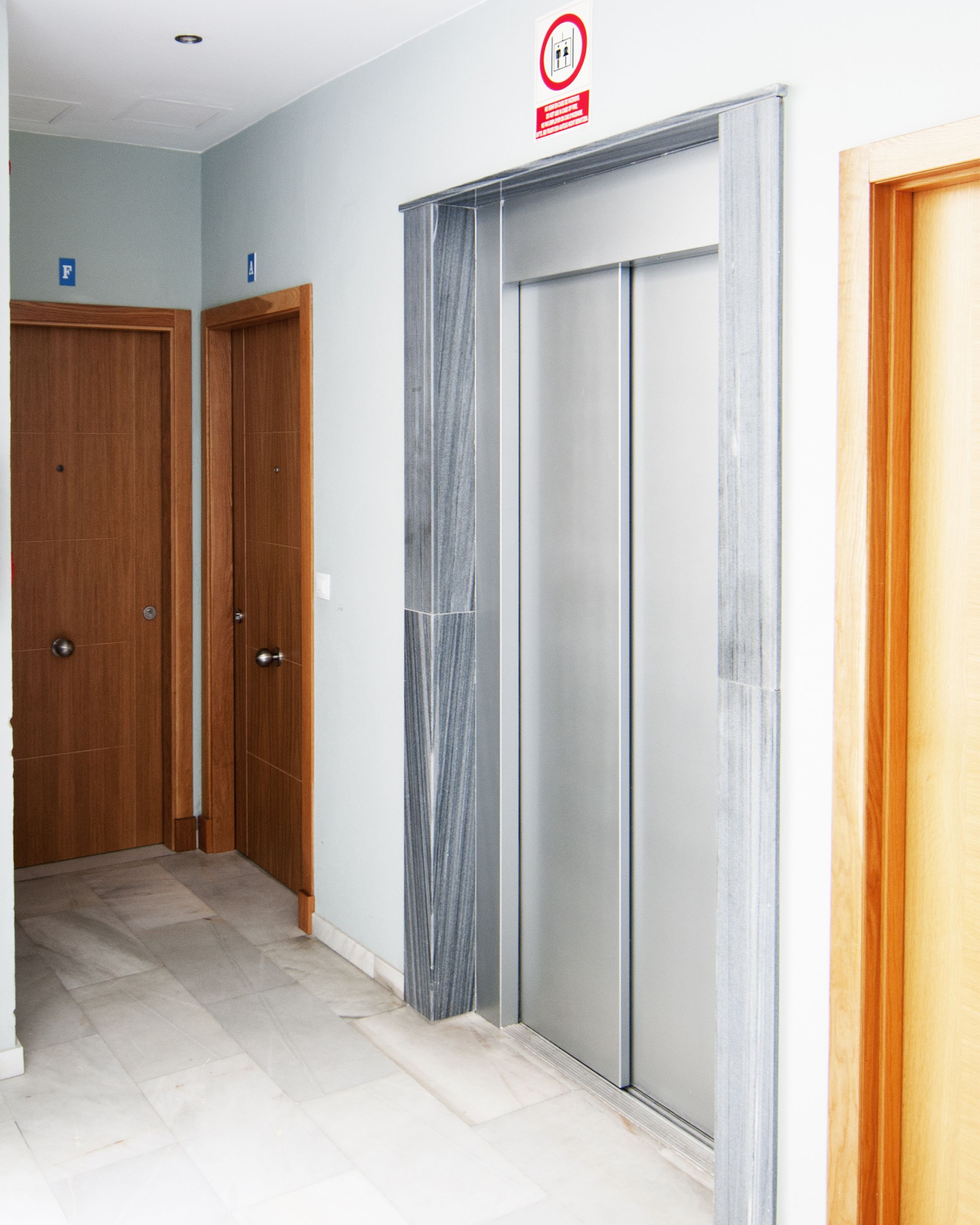 Corredor com portas de madeira e uma porta de vidro deslizante.