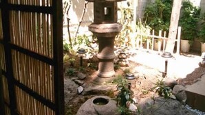 A traditional Japanese garden with a stone lantern, a small pond, and a bamboo fence. - Daiya Ryokan (Kyoto)