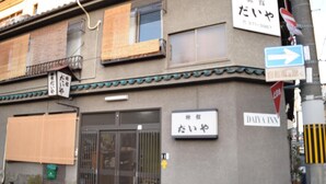 A building with a sign for Daiya Inn, featuring a traditional Japanese architectural style with a tiled roof and a large entrance gate. - Daiya Ryokan (Kyoto)