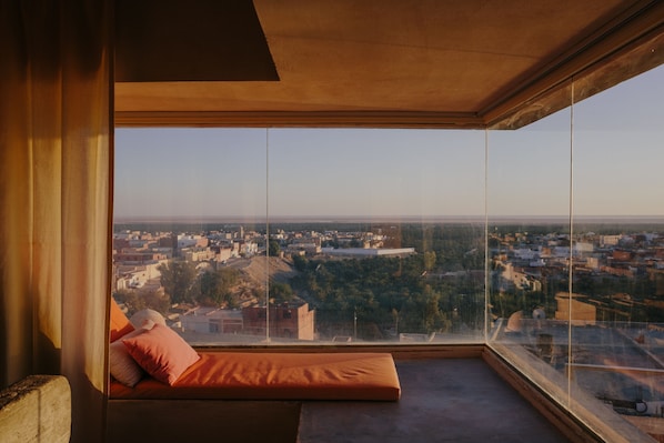 A high-rise room with a large window overlooking a cityscape.