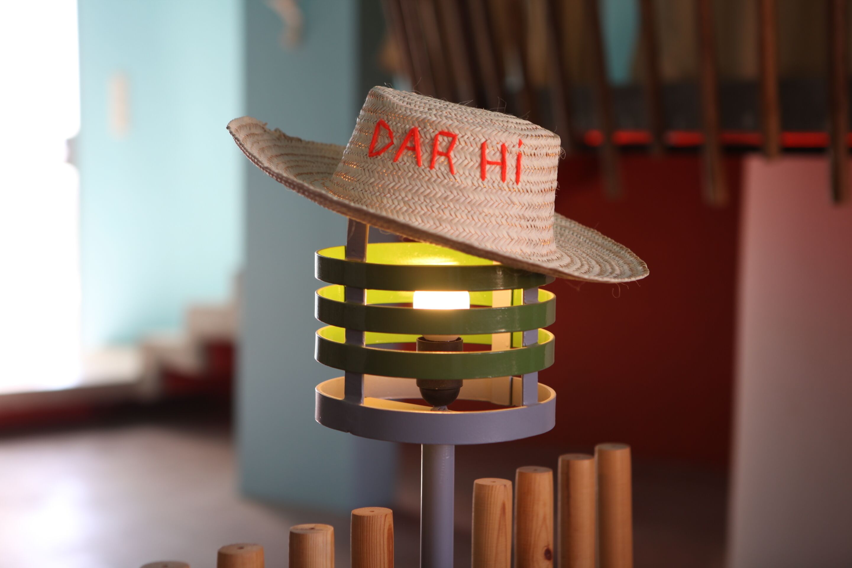 A hat with the text "DAR HI" on a stand with wooden elements.