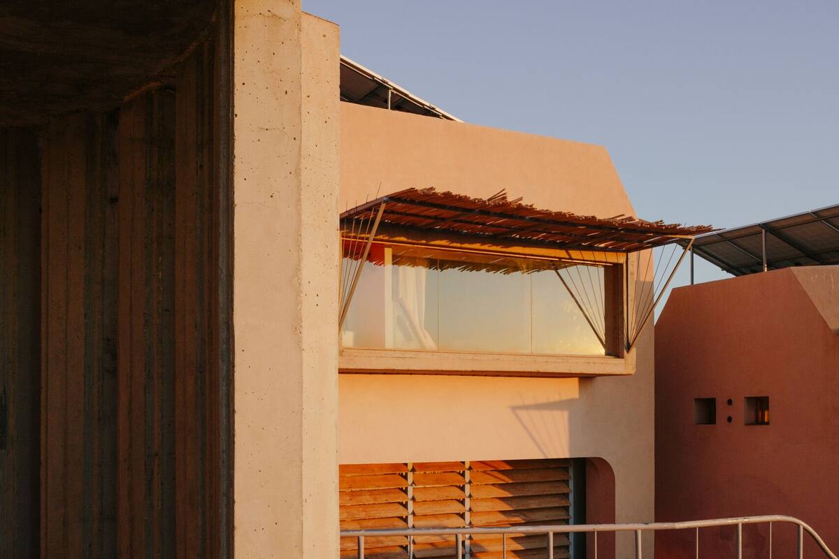 Ein modernes Gebäude mit einer Holzdiele, einem Glasbalkon und einem Metallgeländer.