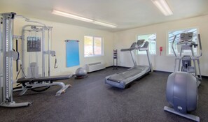 A gym with treadmills, elliptical machines, and weight equipment.
