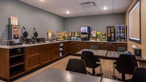 A restaurant with a counter, seating area, and various food items displayed. - Chateau All Suites Hotel (Kindersley)