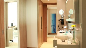 Uma casa de banho de hotel moderna com lavatório, espelhos e zona de duche.