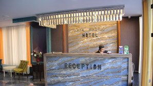 A reception desk with a marble design, a chandelier, and a sign that reads "Kaya Madrid Hotel Reception". - Kaya Madrid Hotel (Istanbul)