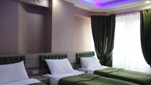 A hotel room with two single beds, green headboards, white bedding, and a large window with green curtains. - Kaya Madrid Hotel (Istanbul)