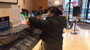 Una recepción con mostrador de mármol, una computadora y un dispensador de agua.