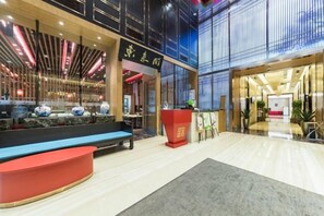 A hotel lobby with a reception desk, seating area, and a large window. - Donghuang Kaili Hotel (Beijing)