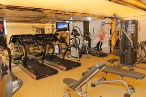 Ein Fitnessstudio mit Laufbändern, Crosstrainern und Gewichten.