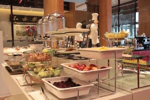 En buffet med forskellige retter og serveringsbestik.