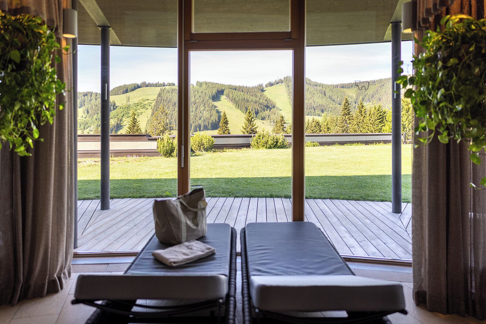 A room with two reclining chairs facing a scenic outdoor view of a forested hillside.