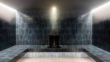 A modern bathroom with a central sink, tiled walls, and a bench.