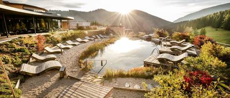 Een binnenzwembad, een buitenzwembad en parasols bij het zwembad